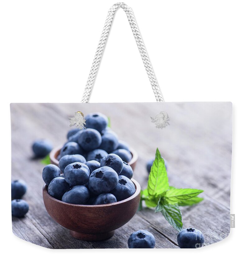Blueberries Weekender Tote Bag featuring the photograph Tasty blueberries in wooden bowl on rustic table background by Jelena Jovanovic