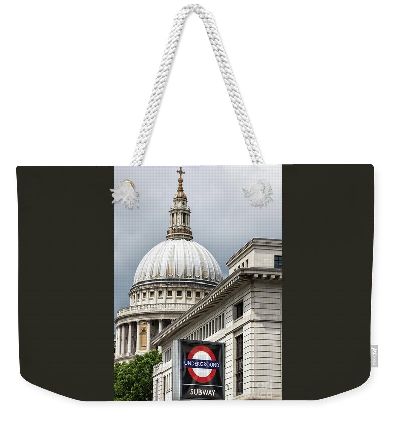Underground Weekender Tote Bag featuring the photograph The dome of St Paul's cathedral behind a London underground roundel sign. Focus on the iconic red, white and blue tube logo in foreground. by Jane Rix