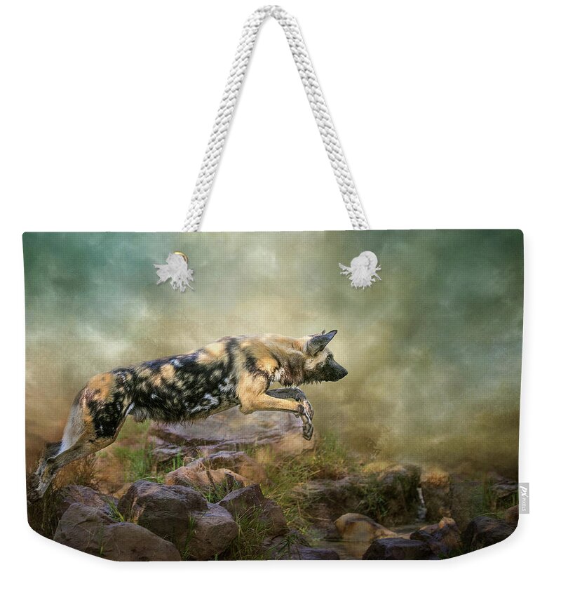 African Wild Dog Weekender Tote Bag featuring the digital art The Leap by Nicole Wilde