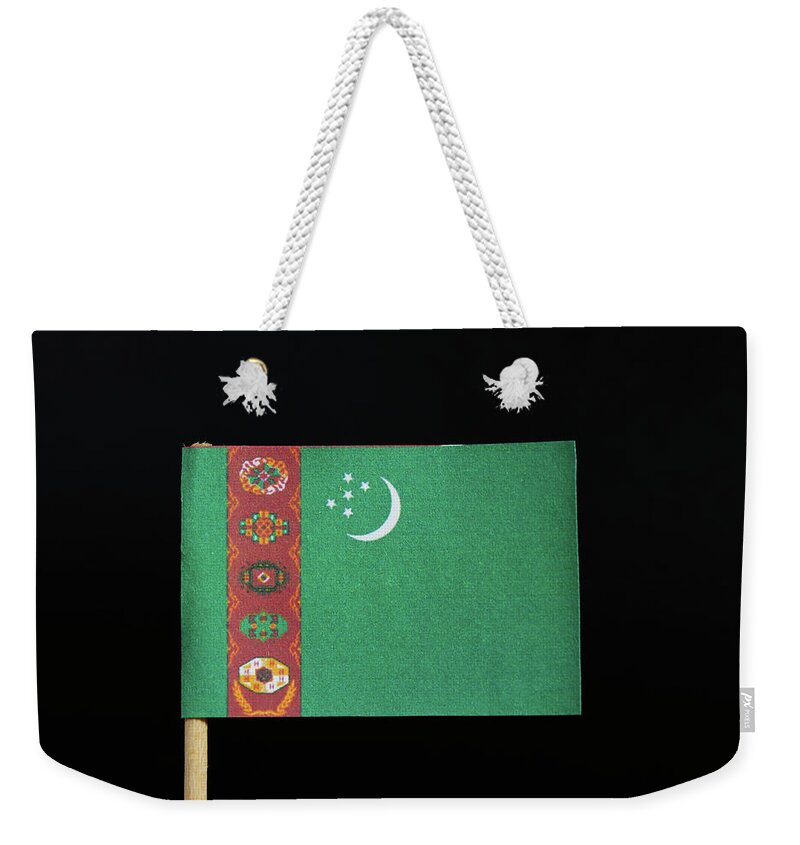 Poverty Weekender Tote Bag featuring the photograph The national flag of Turkmenistan on toothpick on black background. A green field with a vertical red stripe near the hoist side by Vaclav Sonnek