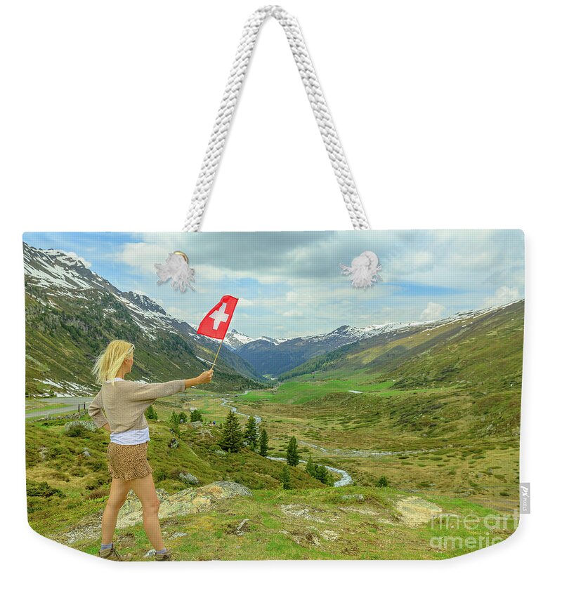 Switzerland Weekender Tote Bag featuring the photograph Tourist girl with swiss flag at Fluela Pass by Benny Marty