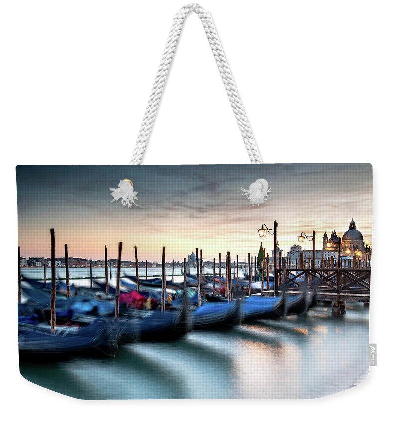 Gondola Weekender Tote Bag featuring the photograph Venice Gondolas moored at the San Marco square. by Michalakis Ppalis