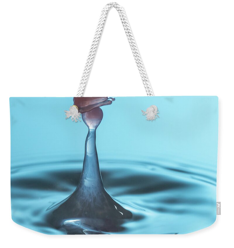 Waterdrop Weekender Tote Bag featuring the photograph Water drop falling onto column of water by Steven Heap