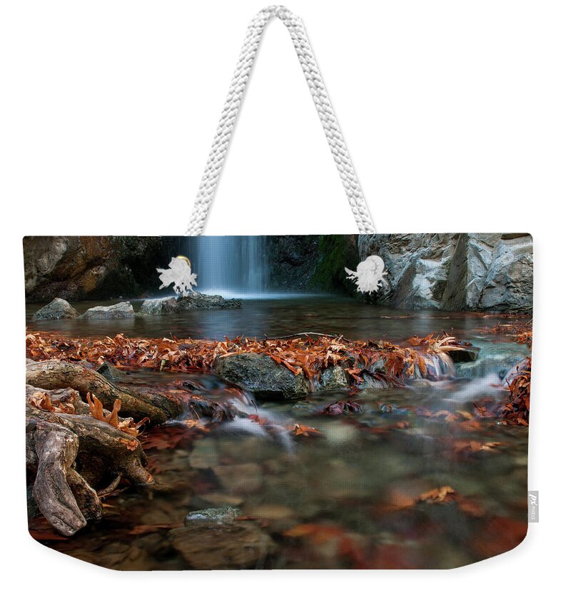 Troodos Weekender Tote Bag featuring the photograph Waterfall and river flowing with maple leaves on the rocks on the river in Autumn by Michalakis Ppalis