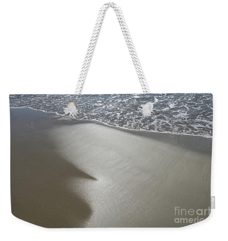 Sandy Beach Weekender Tote Bag featuring the photograph Wet sand, sea water and reflections of sunlight by Adriana Mueller