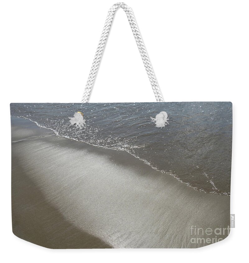 Sandy Beach Weekender Tote Bag featuring the photograph Wet sand, sea water and reflections of sunlight 2 by Adriana Mueller