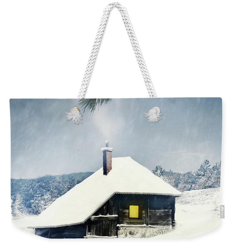 Lodge Weekender Tote Bag featuring the photograph Wooden house covered with snow in winter mountain landscape. by Jelena Jovanovic