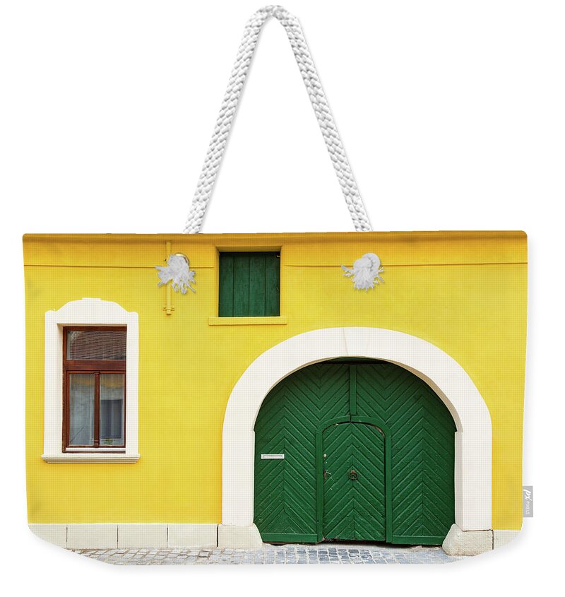 Arch Weekender Tote Bag featuring the photograph Yellow facade of old house by Viktor Wallon-Hars
