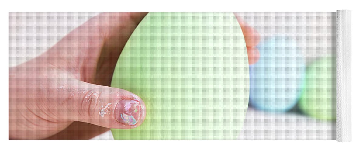 Easter Yoga Mat featuring the photograph Hand holding one Easter Egg. by Michal Bednarek