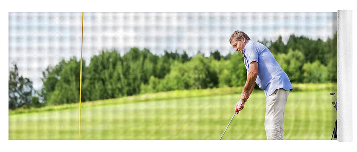 Man Yoga Mat featuring the photograph Senior man playing golf. by Michal Bednarek