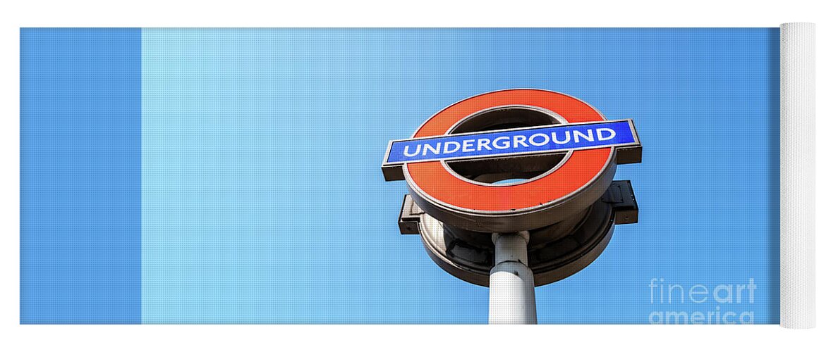 Underground Yoga Mat featuring the photograph The iconic London Underground roundal sign against a blue sky ba by Jane Rix