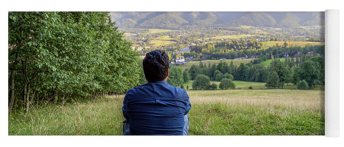 View from behind, A male man hiker traveler sitting in the wild looking and  admiring mountain and nature. Peaceful and calmness scenic view. Active  person outdoor mindfulness living lifestyle concept Yoga Mat
