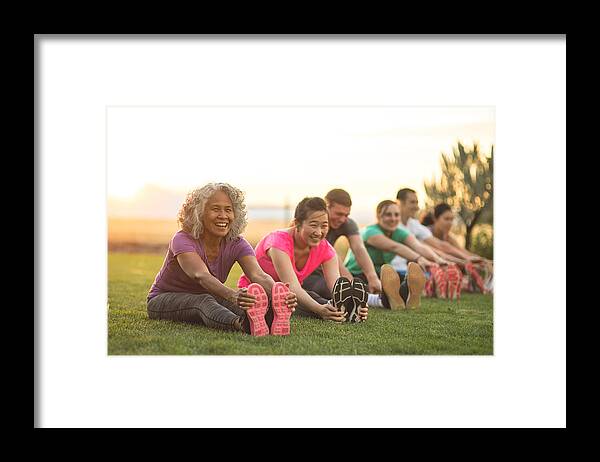 Asian And Indian Ethnicities Framed Print featuring the photograph Fitness Class Stretching #1 by FatCamera