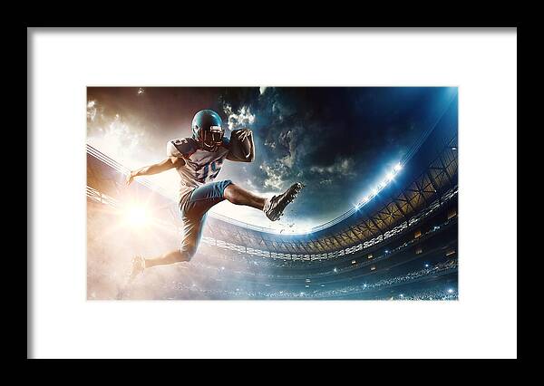 Sports Helmet Framed Print featuring the photograph Football player runs with the ball #1 by Dmytro Aksonov
