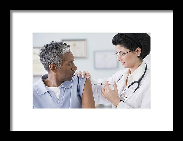 Cold And Flu Framed Print featuring the photograph Middle Eastern female doctor giving shot to patient #1 by Jose Luis Pelaez Inc