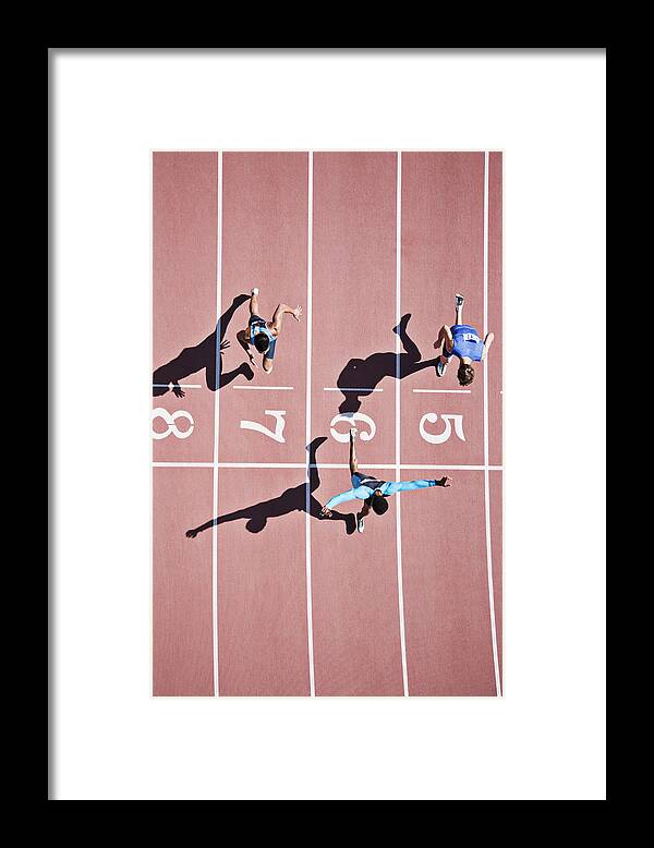 Shadow Framed Print featuring the photograph Runner crossing finishing line on track #1 by Paul Bradbury