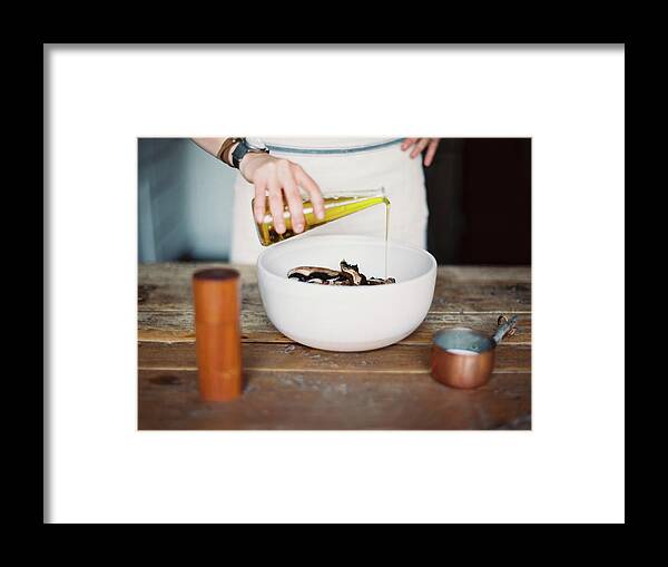 Material Framed Print featuring the photograph A Domestic Kitchen. A Woman Wearing An by Mint Images - Britt Chudleigh