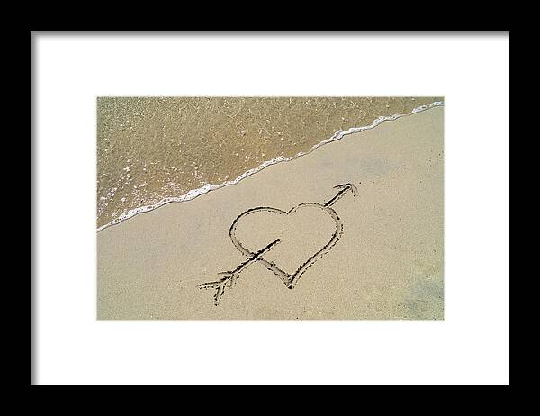 Water's Edge Framed Print featuring the photograph A Love Heart Drawn In Sand by Travelpix Ltd
