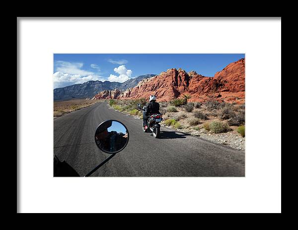 Crash Helmet Framed Print featuring the photograph A Motorbike Rider In A Rocky Landscape by Russell Monk