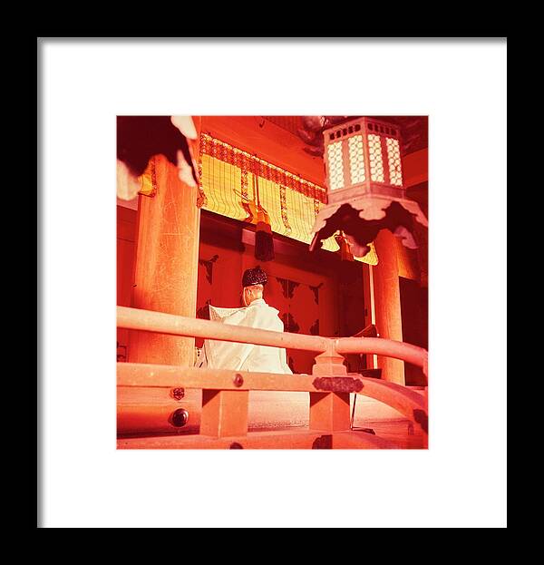 Lifestyle Framed Print featuring the photograph A Priest Praying In A Shinto Shrine by Nick De Morgoli