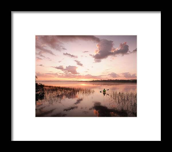 Clouds Framed Print featuring the photograph A Woman Kayaking In Birch Lake by Christian Heeb