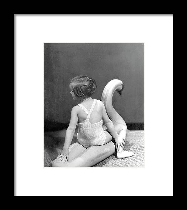 Studio Shot Framed Print featuring the photograph A Young Girl Sitting On A Toy Swan by Horst P. Horst
