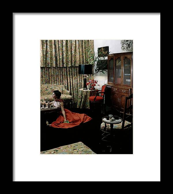 Indoors Framed Print featuring the photograph A Young Woman Sitting On The Floor In The Living by Horst P. Horst