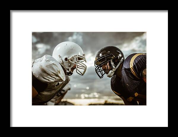 Young Men Framed Print featuring the photograph American football players confronting before the beginning of a match. by Skynesher