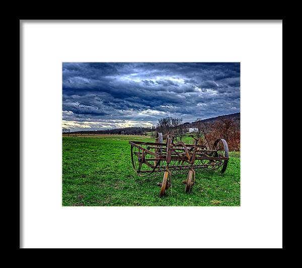 Landscape Framed Print featuring the photograph Antique Hay Rake under as stormy sky by Chris Bordeleau