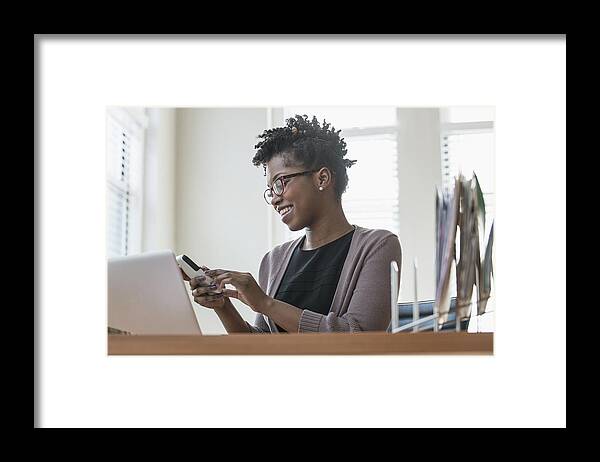 Working Framed Print featuring the photograph Black businesswoman using cell phone in office by Jose Luis Pelaez Inc
