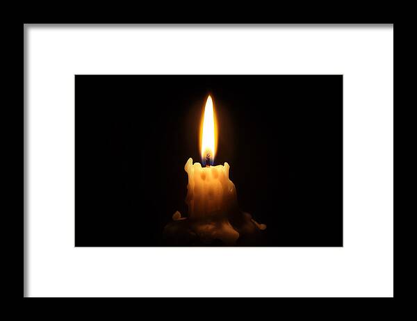 Black Background Framed Print featuring the photograph Bright waxy candle burns down by Gacooksey