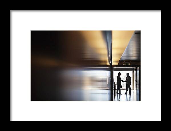 Young Men Framed Print featuring the photograph Businessman shaking hands together in corridor by Sam Edwards