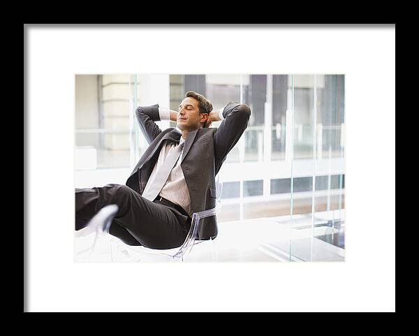 Hands Behind Head Framed Print featuring the photograph Businessman sitting at desk with feet up by Paul Bradbury