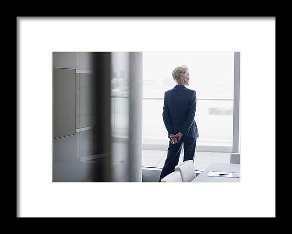Corporate Business Framed Print featuring the photograph Businesswoman standing at window in office by Sam Edwards