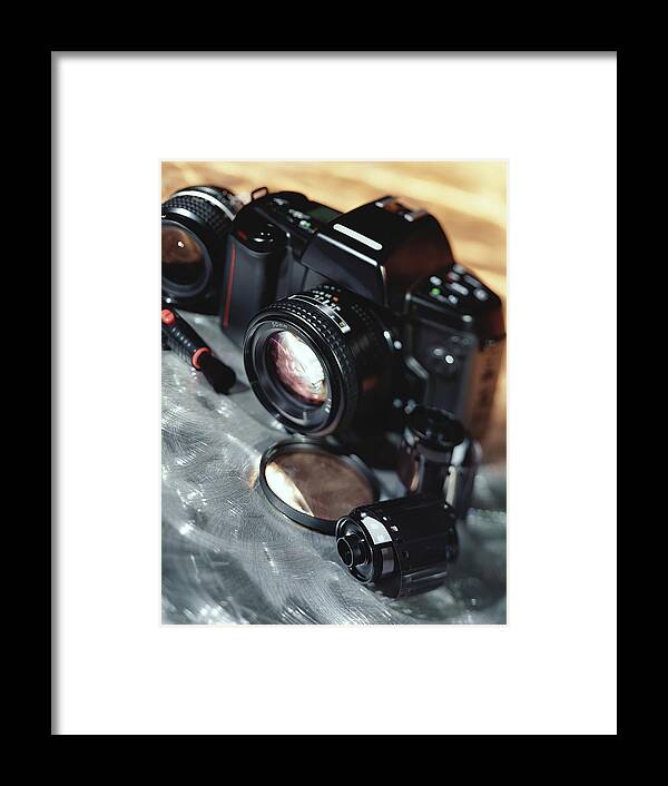 Camera Film Framed Print featuring the photograph Camera, lenses, and film canister by Stockbyte