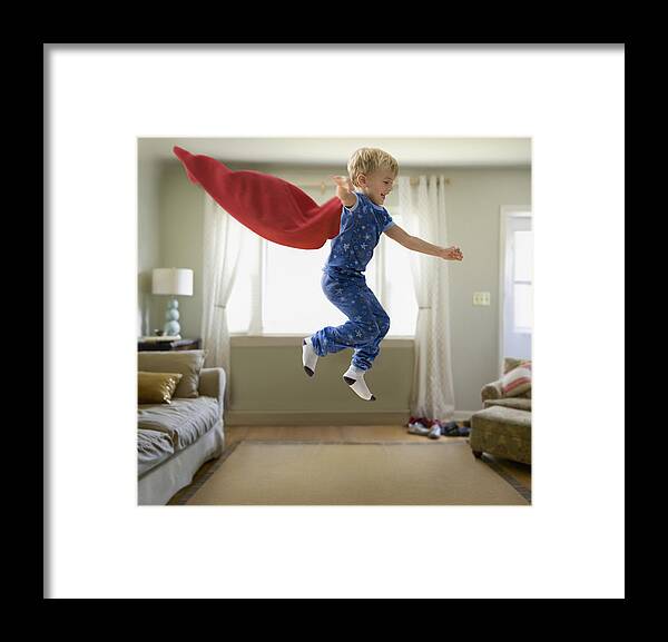 4-5 Years Framed Print featuring the photograph Caucasian boy in superhero costume jumping through the air by Jose Luis Pelaez Inc