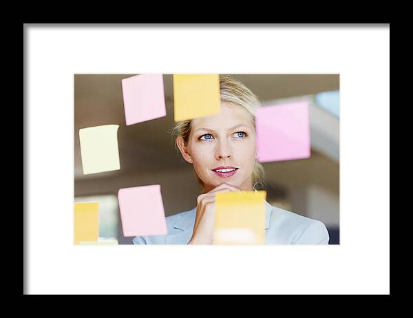 People Framed Print featuring the photograph Contemplative business woman with sticky notes on glass window by GlobalStock