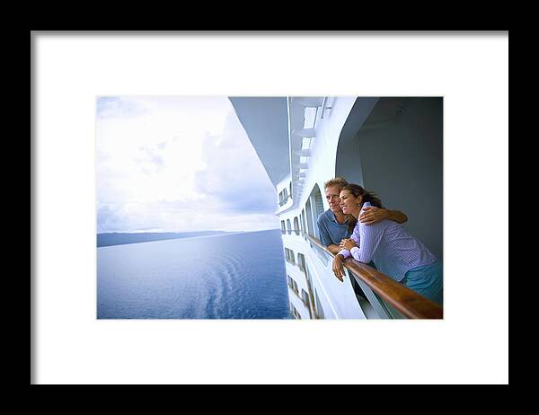 Heterosexual Couple Framed Print featuring the photograph Couple leaning on rail of cruise ship, looking at ocean by David Sacks