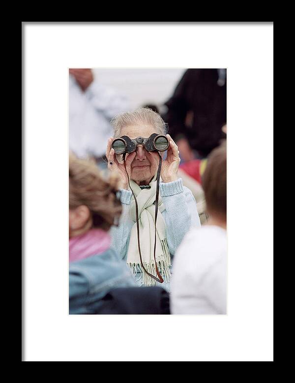 Woman Framed Print featuring the photograph Elderly Woman Uses Binoculars by Martin Riedl/science Photo Library