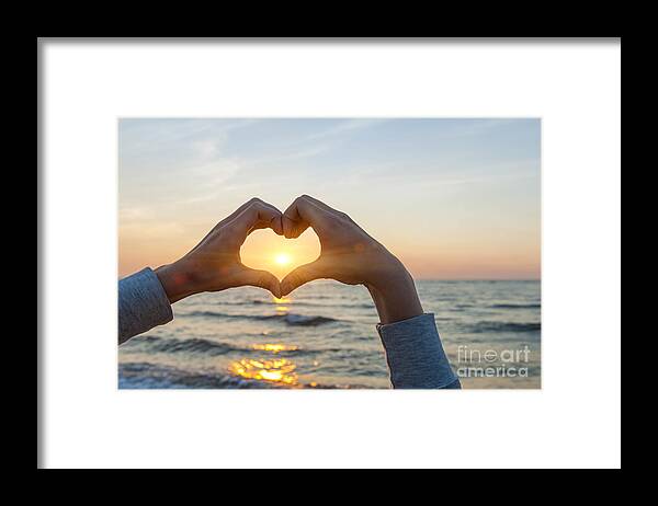 Heart Framed Print featuring the photograph Fingers heart framing ocean sunset by Elena Elisseeva