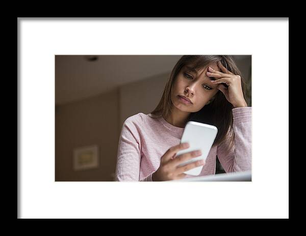 Problems Framed Print featuring the photograph Frustrated Mixed Race woman texting on cell phone by JGI/Jamie Grill