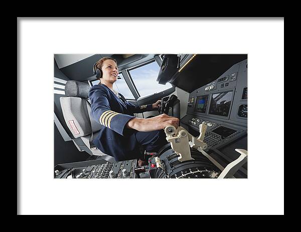 Expertise Framed Print featuring the photograph Germany, Bavaria, Munich, Woman flight captain piloting aeroplane from airplane cockpit by Westend61
