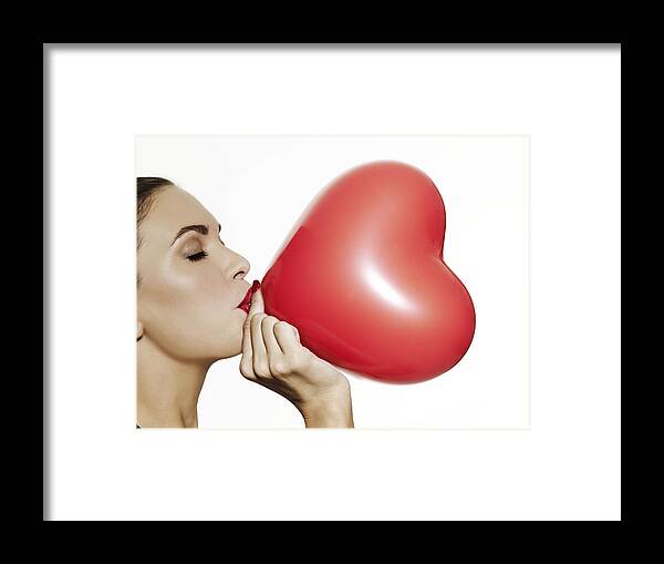 People Framed Print featuring the photograph Girl blowing up a red heart shaped balloon by Elizabeth Hachem