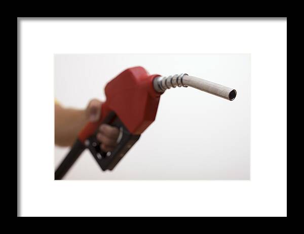 People Framed Print featuring the photograph Hand holding a gas pump by Comstock Images