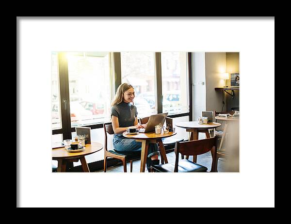 Internet Framed Print featuring the photograph Happy young woman at a cafe using laptop by Alvarez