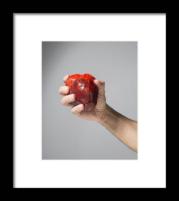 Mature Adult Framed Print featuring the photograph Heart in hand by PM Images