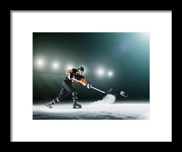 Sports Helmet Framed Print featuring the photograph Ice hockey player passing puck. by Robert Decelis Ltd