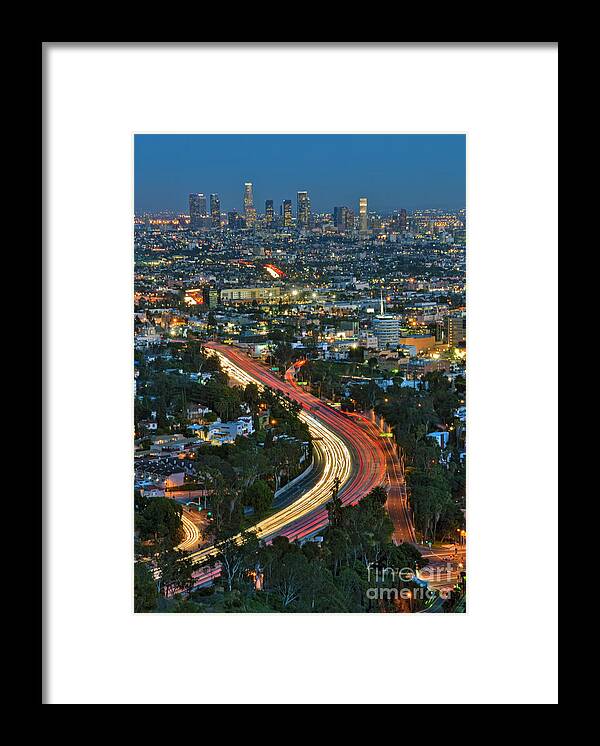 La Skyline Framed Print featuring the photograph LA Skyline Night Magic Hour dusk streaking tail lights Freeway by David Zanzinger