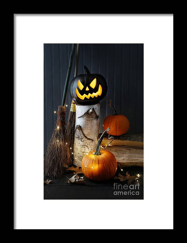 Background Framed Print featuring the photograph Lit pumpkin on log with leaves by Sandra Cunningham