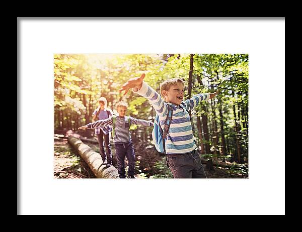 Eco Tourism Framed Print featuring the photograph Little hikers walking on a tree trunk in forest by Imgorthand